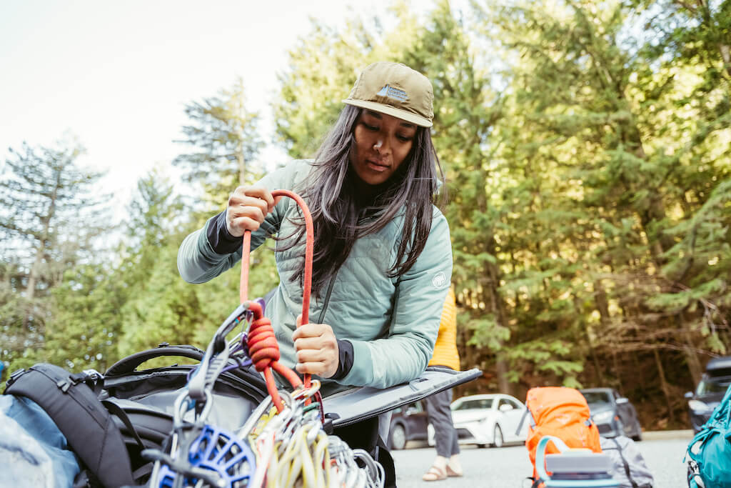 a photo of Emma Contaoe checking her climbing gear