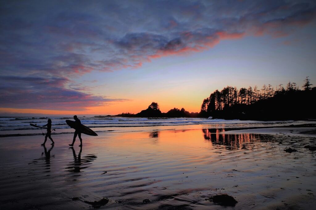 photo at sunset of Cox Bay, Tofino and surfers